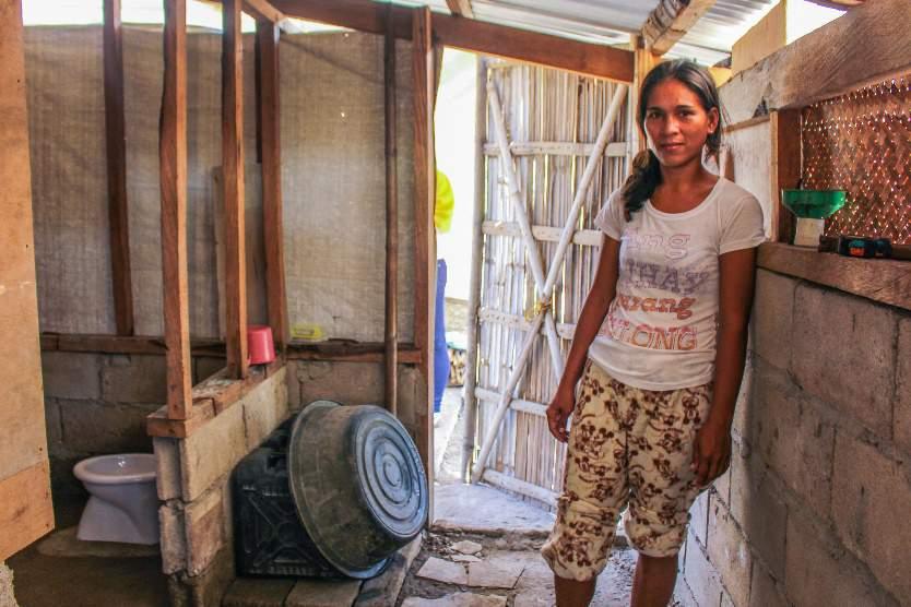 Beeld: Save the Children. Ivy, 28, naast de pas geïnstalleerde wc in haar nieuwe huis.
