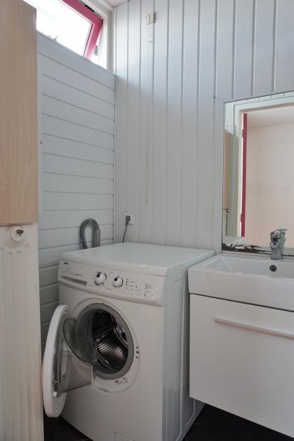 Deze ruimte is circa 3 m² groot en voorzien van een douche, wastafel en de wasmachine