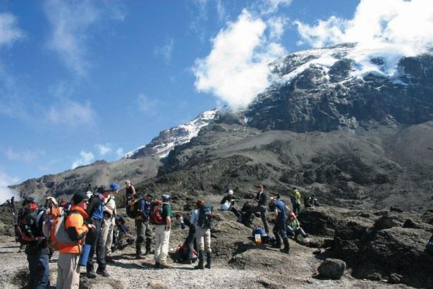 uit te wisselen onder het genot van de vele kopjes thee die je moet drinken op deze hoogte. Op de vierde dag van de trekking zien we de zon opkomen achter de Mawenzipiek.