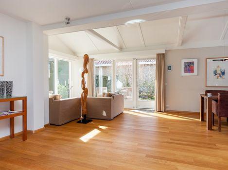 Extra opbergruimte, gootsteen en de opstelling voor de was/droogcombinatie. De royale en zonnige woonkamer, kent een stijlvolle indeling.