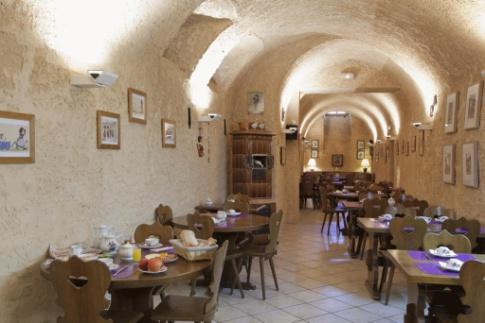 Het hotel beschikt over een bar en een gewelfde eetzaal waar u het fresco 'De Franciscanen' van André Wenger kunt bewonderen.