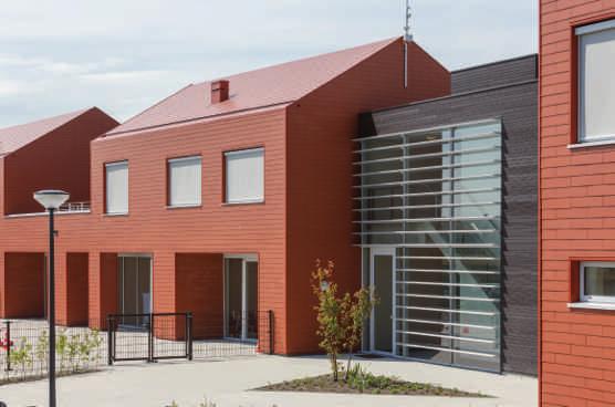 De verschillend vormgegeven gebouwen van deze fase werden tot een eenheid verbonden door het gebruik van keramisch rode vezelcementleien voor gevels en dak.