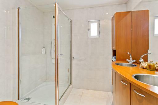 De geheel betegelde badkamer is voorzien van een douche met