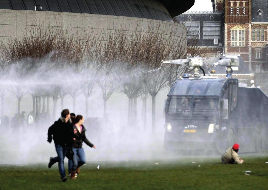 Een waterwerper van de Mobiele Eenheid wordt ingezet om scholieren, die zich hebben verzameld op het Museumplein om actie te voeren tegen de 1040-urennorm, uit elkaar te drijven.