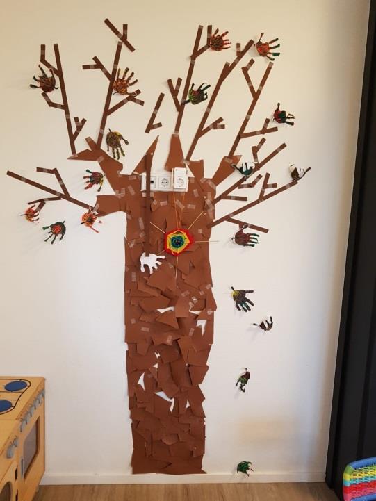 de kinderen. In de boom hangen ook mooie spinnenwebben die gemaakt zijn met stokjes, touw en kastanjes.