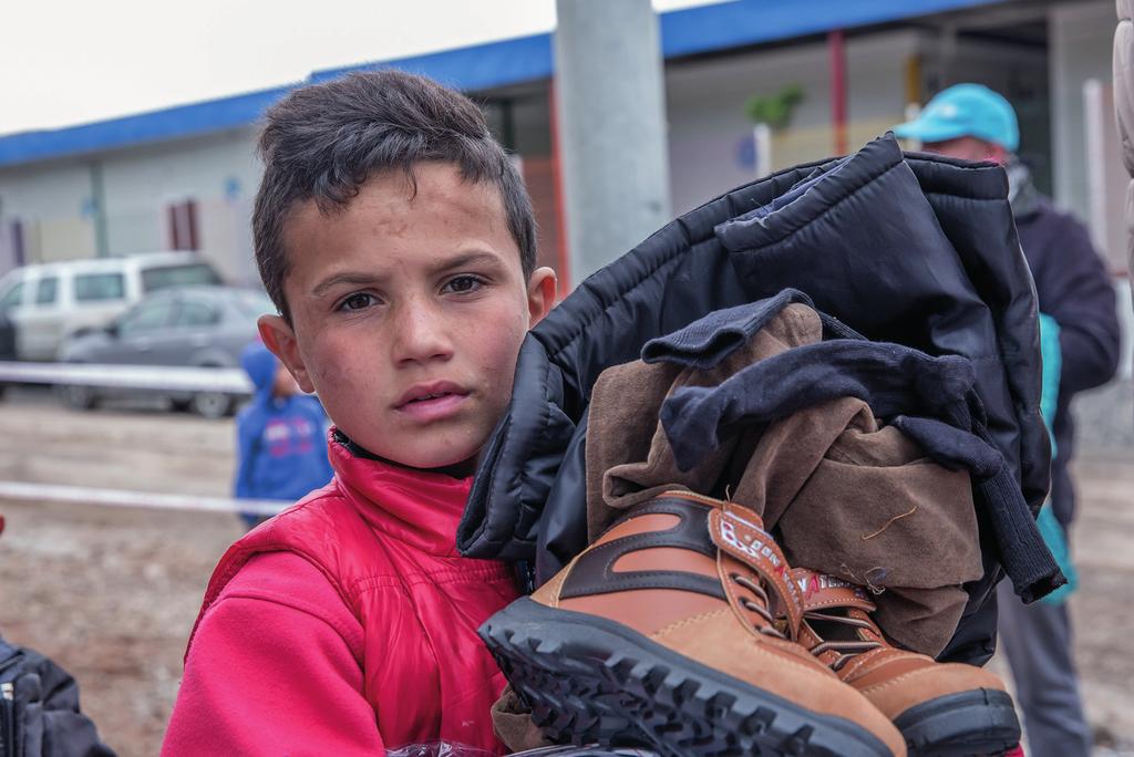 Een Syrische jongen krijgt van UNICEF winterkleding in een vluchtelingenkamp in Irak.