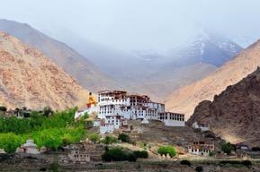 Op een klif die boven de lemen dorpshuizen uitsteekt, ligt het witte klooster in al zijn glorie.