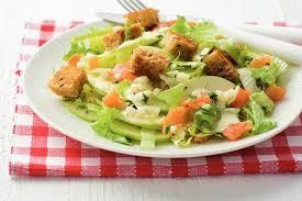 Gezond de zomer door Zomerse salade Schik de sla op een bord Verdeel appelpartjes over de salade Rol de zalmplakjes op en snij ze in stukken.