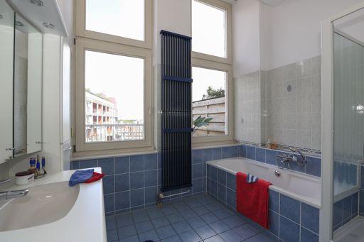 De moderne, ruime badkamer (circa 8 m2) heeft een duobad, een douchecabine, een wastafelmeubel en een designradiator.