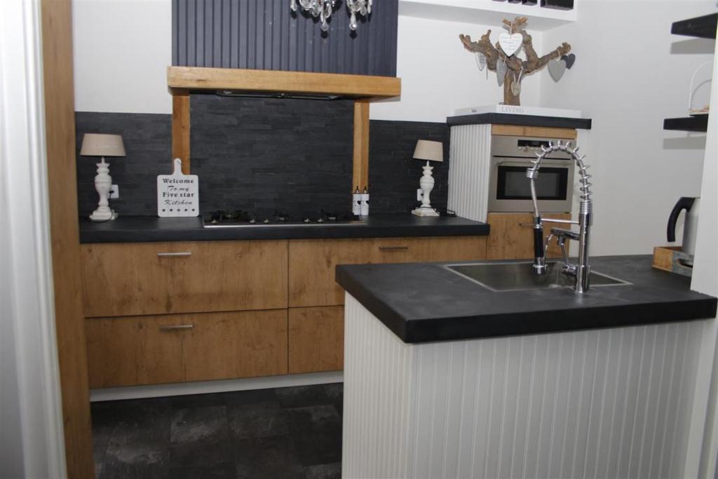 Keuken: De open keuken beschikt over een luxe en robuust keukenblok met betoncire