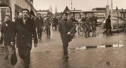 Turkse gastarbeiders verlaten de poort van Philips in Hilversum.