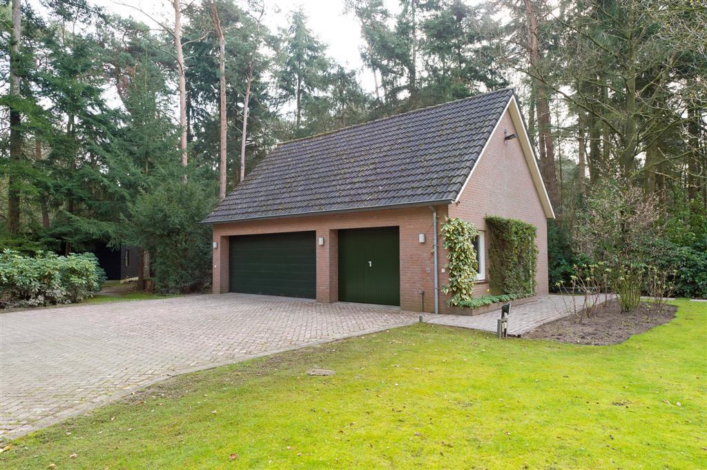 Garage en carport: De vrijstaande garage is opgetrokken uit metselwerk en het dak is met pannen gedekt.