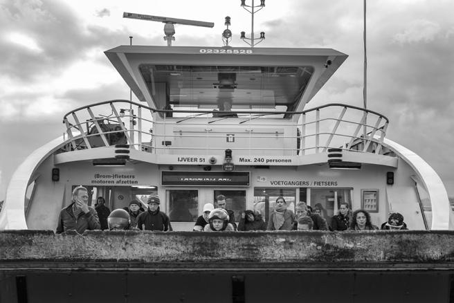 Veel mensen maken gebruik van een pont in Amsterdam om de oversteek over het IJ te maken.