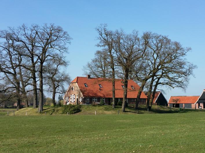 De boerderij is gebouwd op een heuvel omringd door eeuwenoude eikenbomen en een gracht in de vorm van