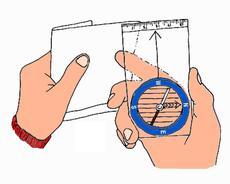 Ga "achter" het kompas staan, hou het kompas ter hoogte van je lichaam, zo'n 50 cm ervoor. Nu kan je over de pijl mikken naar een doel (een opvallende boom, een heuveltje,.