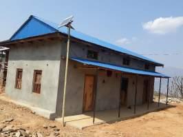 Huis-aan-huis wordt informatie verstrekt over aardbevingsbestendig bouwen van huizen (Sindhuli District) Nieuw gebouwd huis in Sindhuli District met zonnecel voor zonneenergie Uitdagingen en