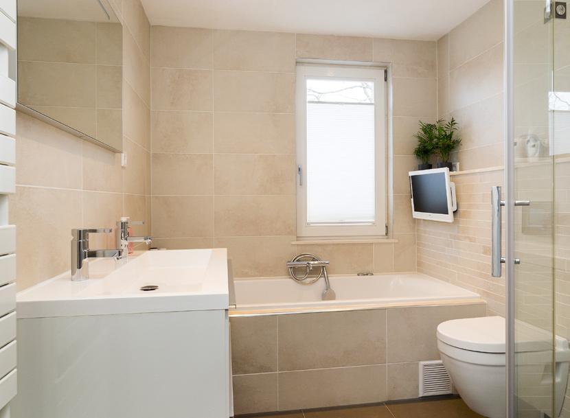 Badkamer Geheel betegelde luxe badkamer met een inloopdouche, ligbad met