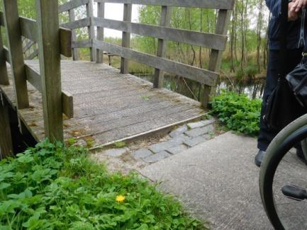 54. Halverwege is een vlakke brug waarbij de aansluitende bestrating is verzakt en een te grote drempel heeft. 54.1.