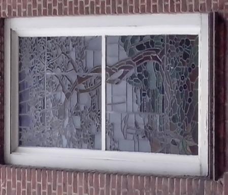 Hooogeinde 11 Het gebrandschilderd raam in het oude postkantoor.