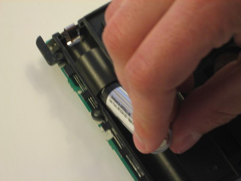 Verwijder de onderste batterijen die door de batterij te drukken