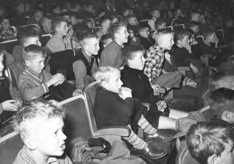 Chef-operateur Rodenburg bleef tot de laatste avond op zijn post. Kinderen van de Aloysiusschool genieten in het Minervatheater van de film, 1956. Bronnen Noord-Hollands Archief: T.2095, inv.nr.