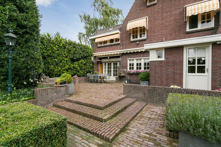 EXTERIEUR Aan de voorzijde van de woning bevindt zich de ruime oprit voorzien van sierbestrating en de prachtig