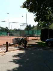 De weg loopt langs het tennisterrein en het kunstgrasveld van FC Latem.