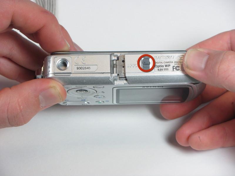 Stap 2 Unlock het batterijcompartiment door het schuiven van de vergrendeling in de ontgrendelde stand (weg van de pijl).