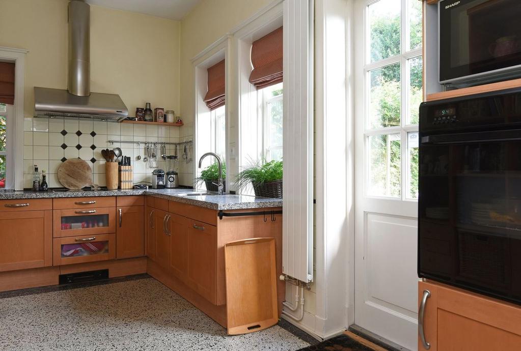 Keuken Vanuit zowel de hal als de eetkamer is de ruime L-vormige keuken met granito vloer te