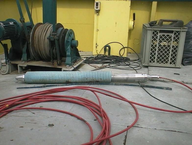 Figuur 4 a) De MEDUSA-detector in een gedeelte van de blauwe beschermende PVC-buis. B). Zichtbaar zijn de kabels waarmee de detector achter het schip wordt voortgetrokken 2.