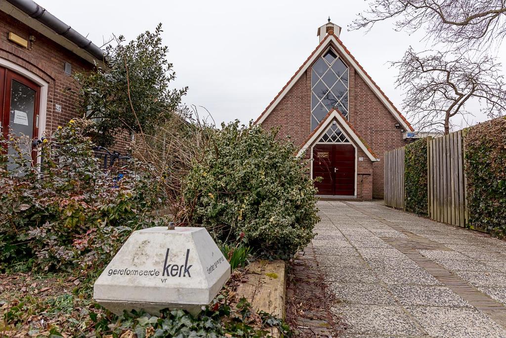 Door de terug liggende situering ligt het gebouw verscholen tussen omringende bebouwing.