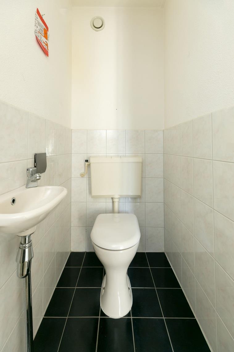meterkast en een deels betegeld toilet