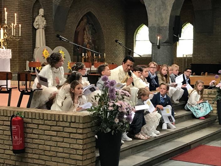 In de fraai versierde kerk werden de kinderen onder muziek naar voren begeleid door deken Spee, father Patrick