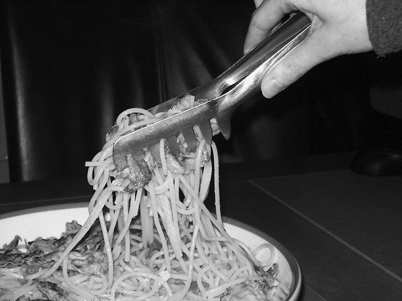 Pastatang Charlotte schept aan tafel spaghetti op met een pastatang.