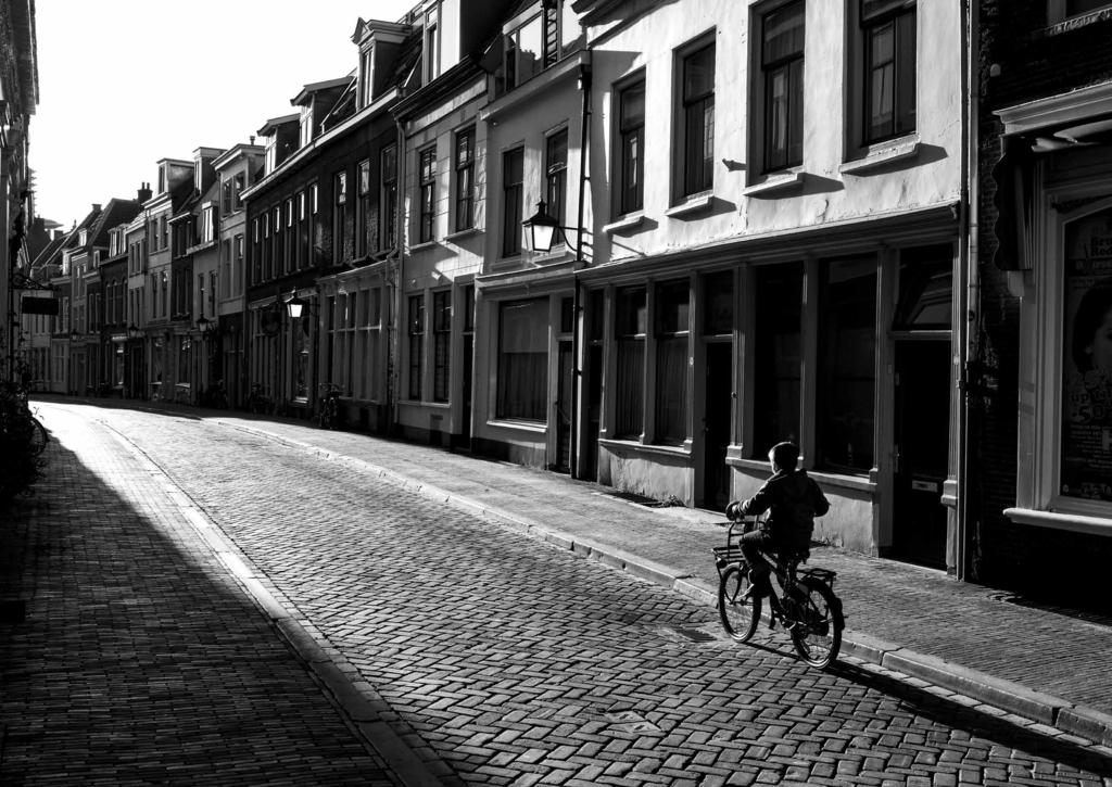 Foto genomen in Utrecht vanaf de Oudegracht, kijkend in de richting van de Springweg, fietst de jongen over de