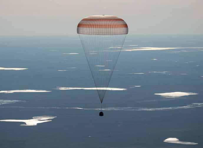 De Soyuz MS-2 daalt onder haar parachute, enkele minuten voor de landing in Kazachstan. [NASA] in de Atlantische Oceaan.