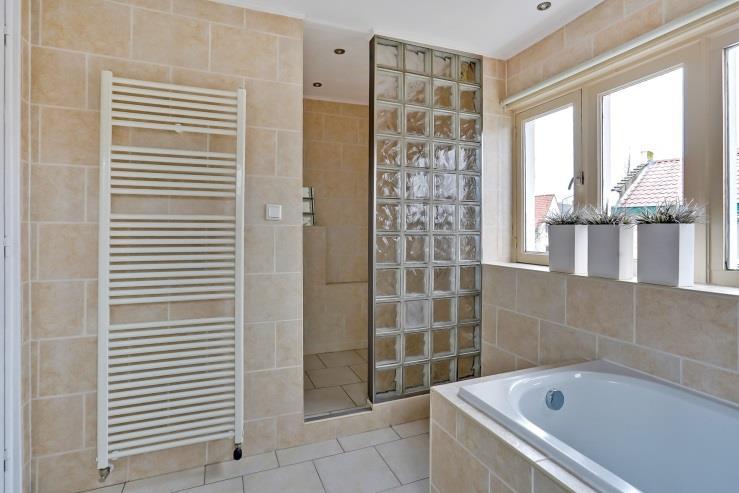 8 m²) is voorzien van een ligbad, een douche met