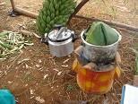 Links: de kookpot is afgedekt met bananenbladeren om het kookvocht binnen te houden. Opmerkelijk, de snelkookpot (drukkookpan), oud en nieuw samen.