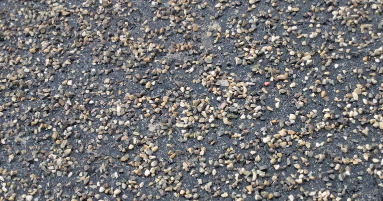 De hoeveelheid van afstrooien is zo gekozen dat de stenen met kleine afstand naast elkaar liggen zodat het asfalttransport en de spreidmachine over de steenslag kunnen rijden zonder het membraan te
