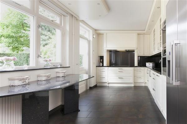 De keuken is voorzien van antracietkleurige tegelvloer, spachtelputz wanden en een stucwerk plafond, alsmede een uiterst luxueuze keukeninrichting.