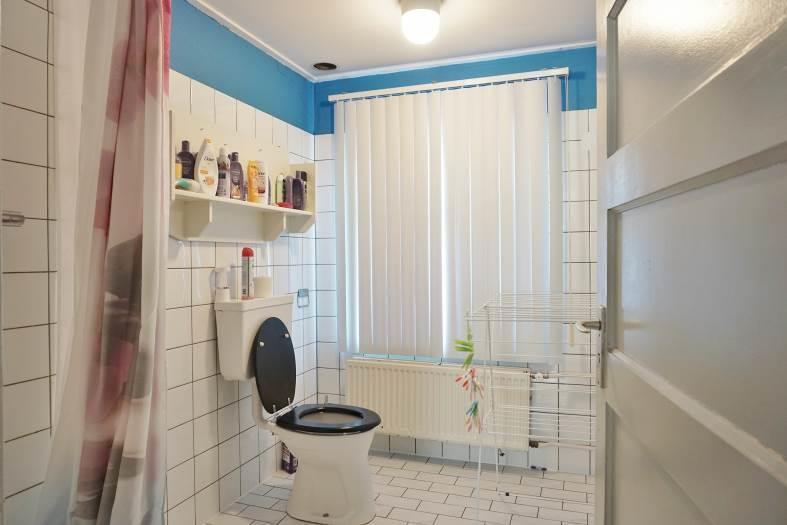 De badkamer is voorzien van een douche en een toilet. Er liggen tegels op de vloer, de wanden zijn grotendeels betegeld en het plafond is gestuukt. Kamer 3 ligt aan de voorzijde.