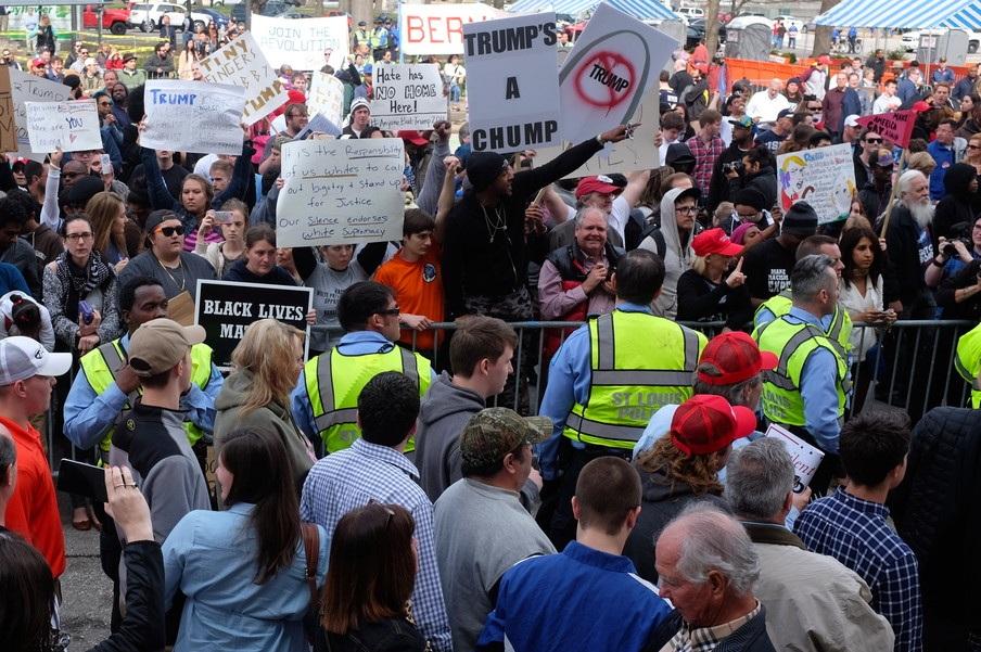 Trumpfans en activisten gescheiden door hekken De politie arresteerde die middag 32 mensen, binnen en buiten de zaal.