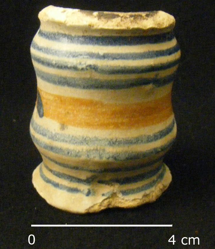 Afb. 12. Foto van een majolica zalfpotje uit het ophogingspakket op het Kloostertuinterrein. Een ander compleet voorwerp is een onbekend object van roodbakkend aardewerk (afb. 13).