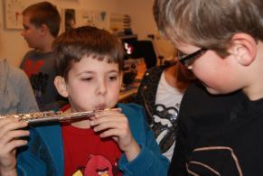 Enthousiast trekken de kinderen van het ene naar het andere instrument en proberen vol inzet geluid uit het instrument te krijgen. De ene lukt het direct, de andere moet er heel veel moeite voor doen.