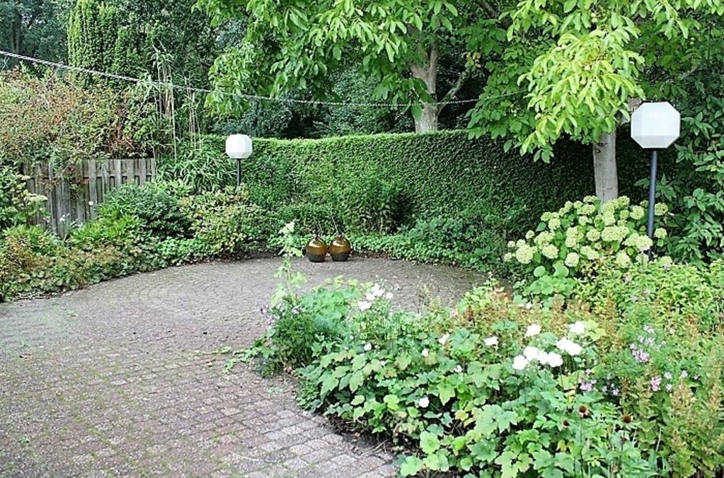 Ligging en indeling Tuin Royale tuin rondom de woning met een grote oprit, de achtertuin is beschut d.m.v.
