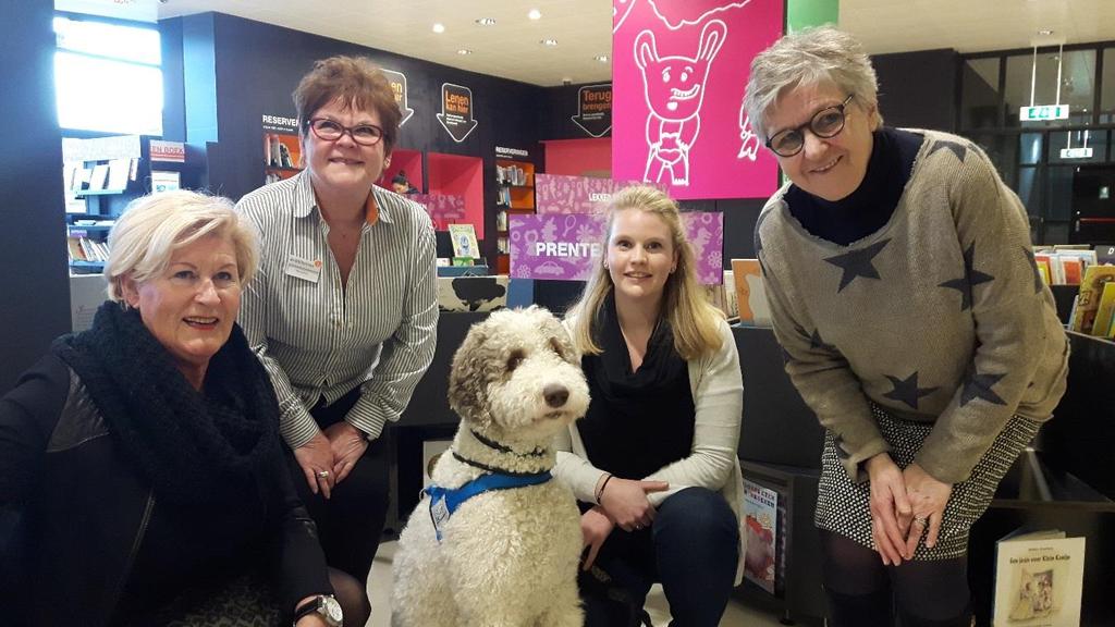 Kwispellezen, pilot in De Bibliotheek Waalwijk (31.620 inw.) Kinderen lezen voor aan een hond.