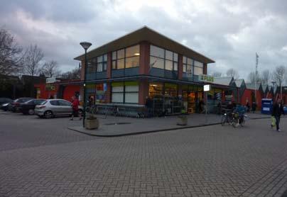 Op de voorgrond van het parkeerplein is het fietspad van de Kees Boekelaan te zien. Supermarkt Plus aan Donsvlinder (links) en scholieren op de fiets op de Kees Boekelaan (rechts) 3.