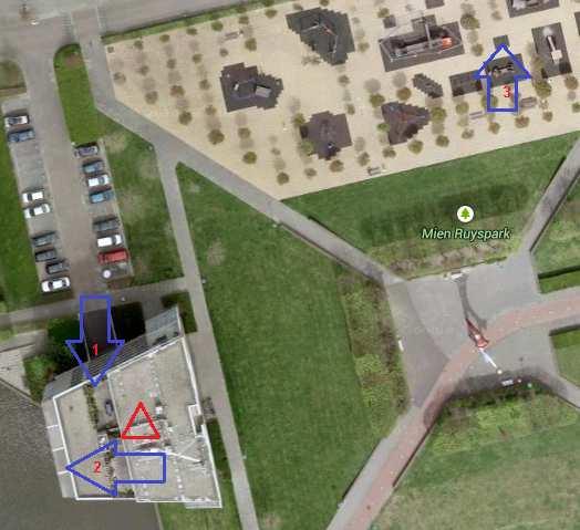 Agentschap Telecom Figuur 2; De blauwe pijlen geven de meetlocatie aan. De rode driehoek geeft de locatie aan van de antenneopstellingen in de mast op het wooncomplex.