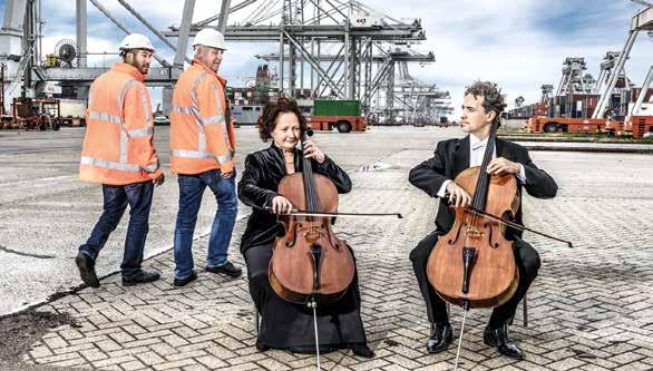 Twee musici spelen bij de haven; voorbeeld van samenwerking tussen het orkest en het bedrijfsleven.