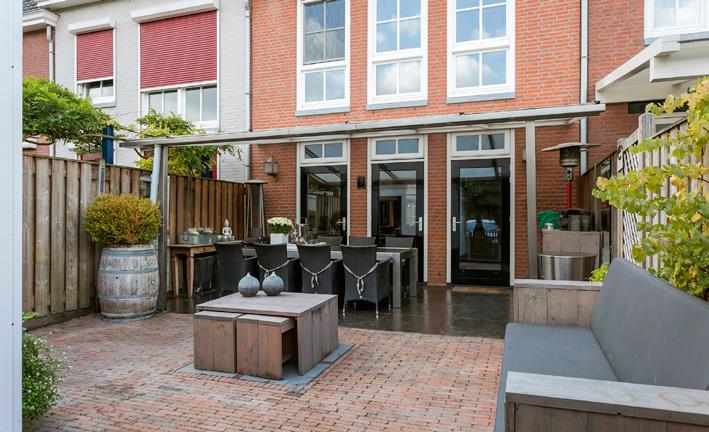 Tuin De grotendeels bestraatte achtertuin is voorzien van een RVS veranda